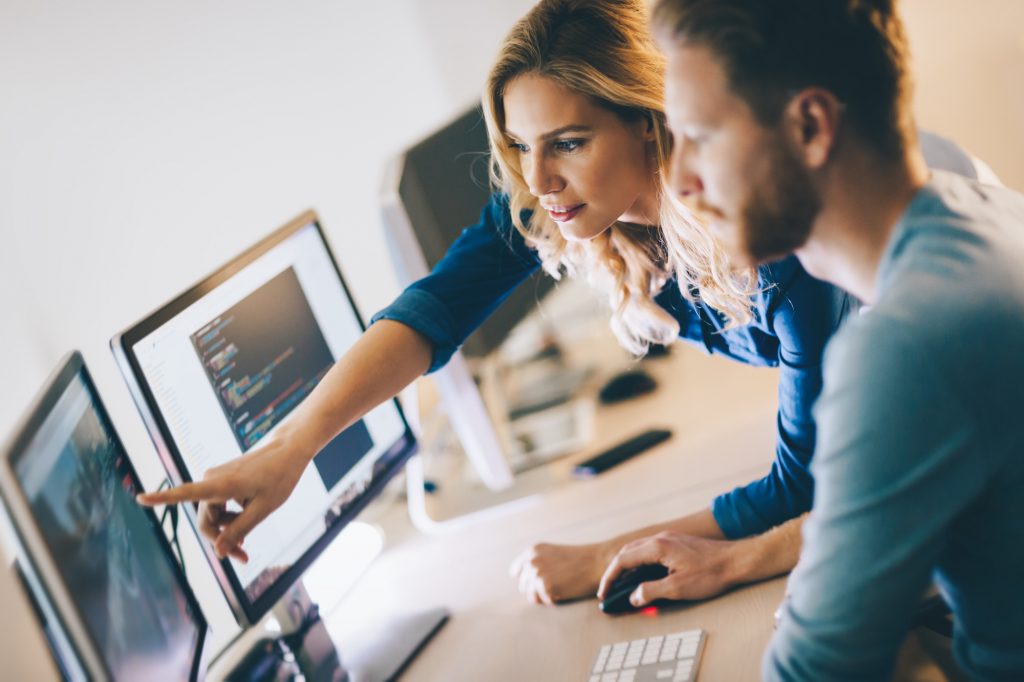 Technology professionals looking at computer monitors